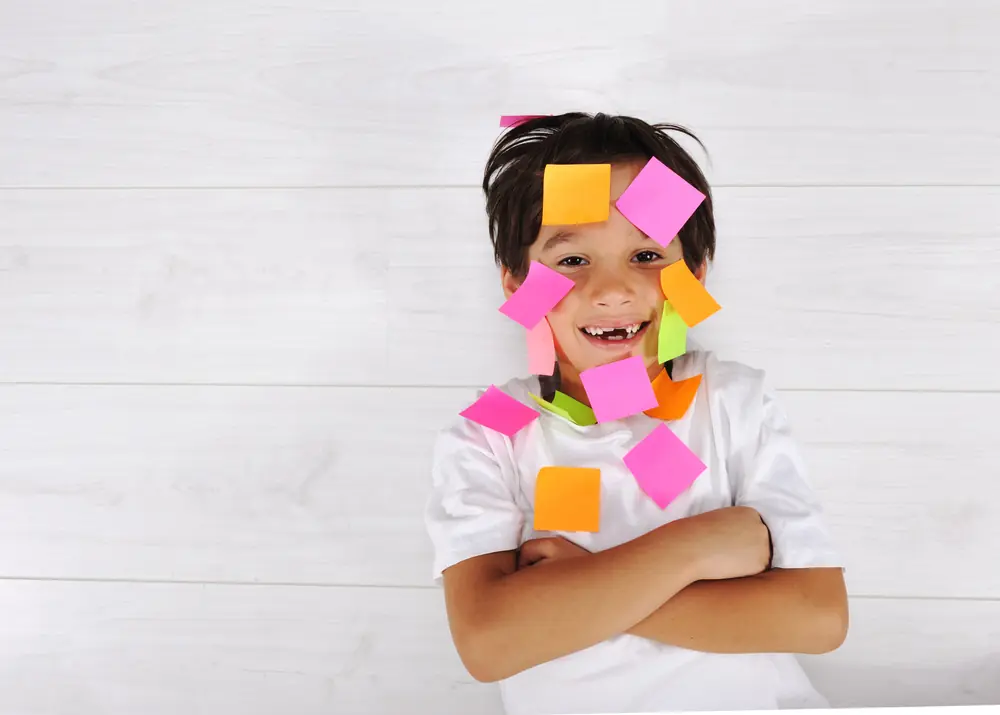 Boy with sticky notes on his face
